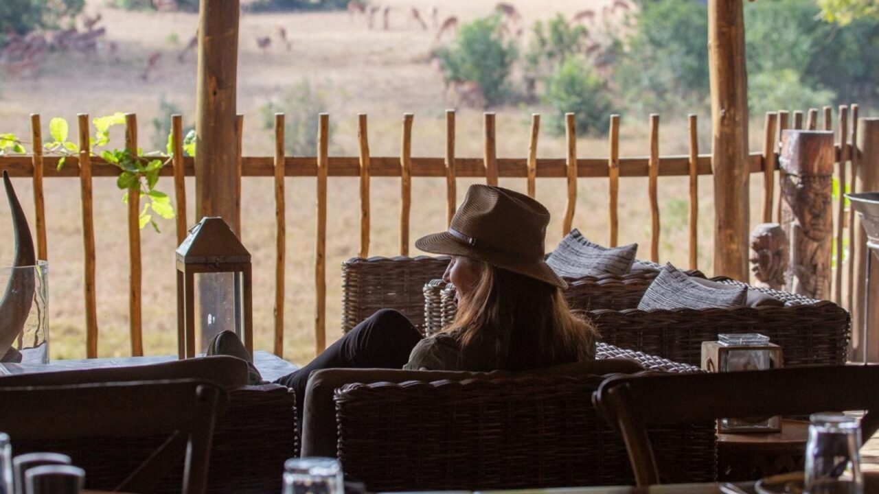 Woman sitting on a sofa on a terrace at Notten's Bush Camp.
