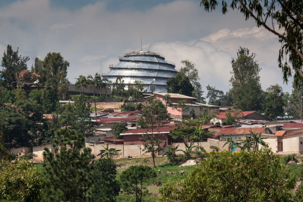 The silver Kigali Covention Centre dome surrounded by squat red roofed cottages in Rwanda.